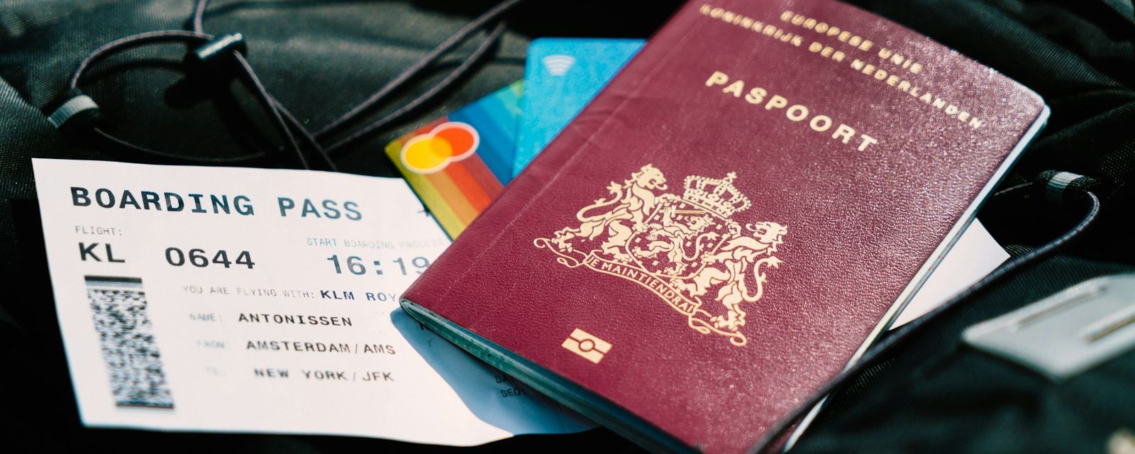 A passport and a boarding pass are on a bag