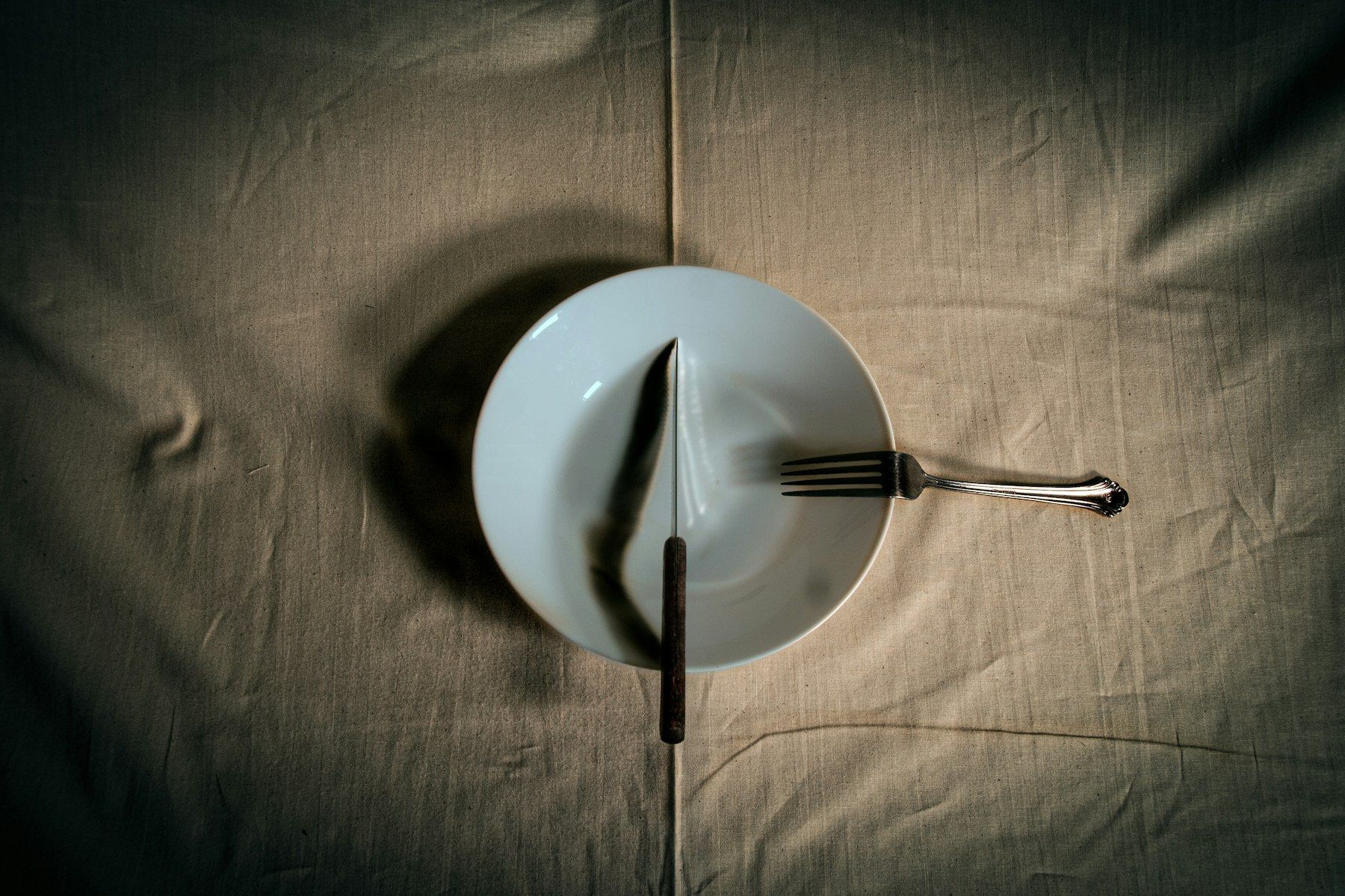 Stainless steel fork on white round plate