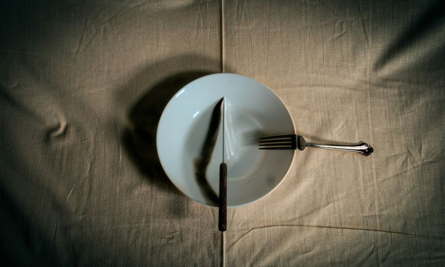 Stainless steel fork on white round plate