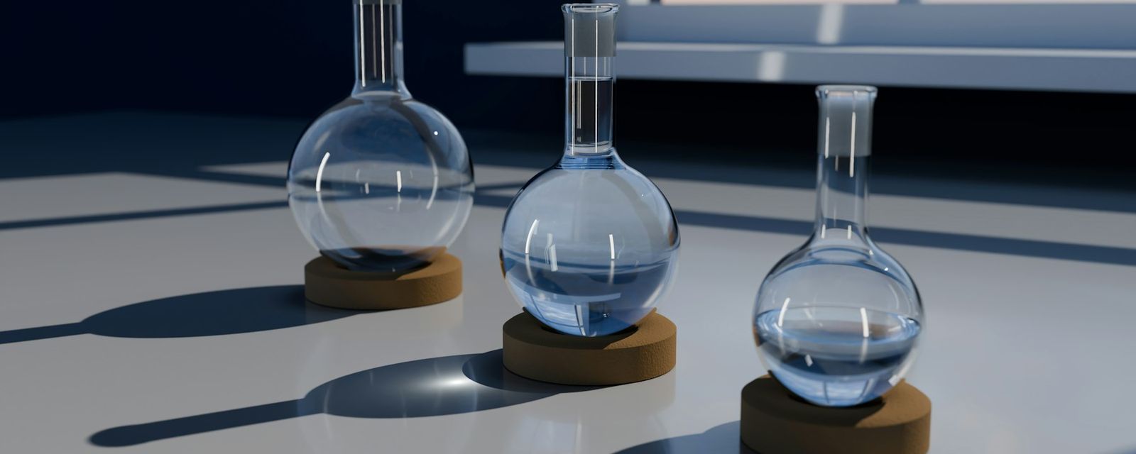 A 3D render of three glass round-bottom flasks on cork stands on a white surface