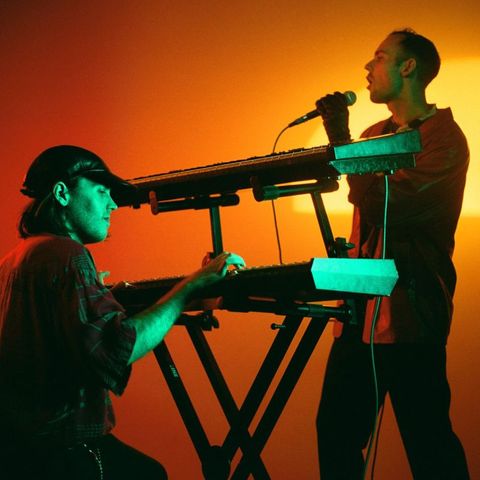 Musicians Body of Light photographed in a studio setting, with saturated light, pictured with synths and microphones