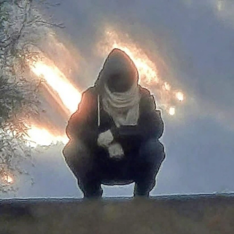 crouching person haloed by sunlight.