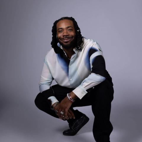 Musician DRAM posted in a photography studio, on a clean white backdrop