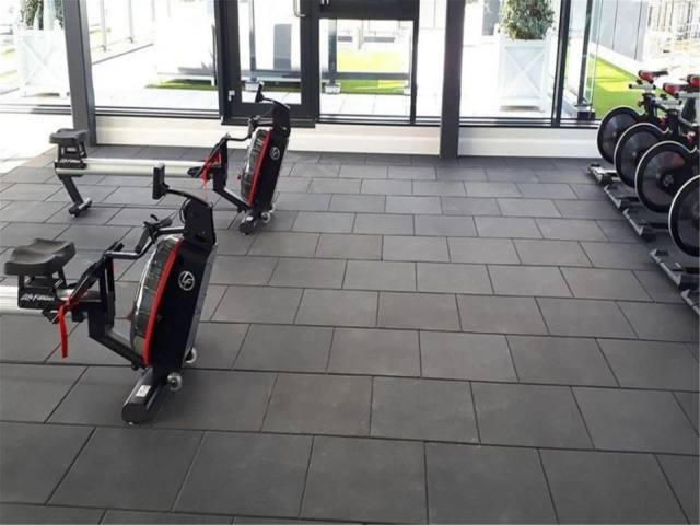 Gri karo kauçuk zemin kaplı fitness salonu ve kardiyo ekipmanları