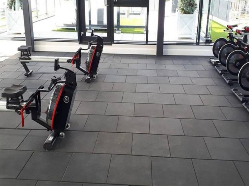 Gri karo kauçuk zemin kaplı fitness salonu ve kardiyo ekipmanları