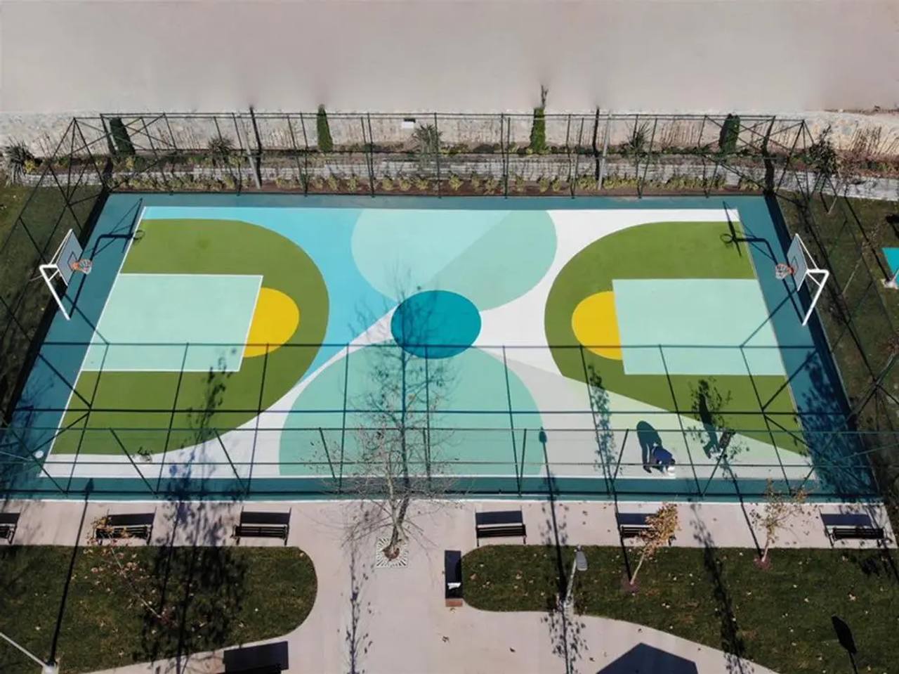 Turkuaz ve sarı akrilik zeminli çok amaçlı spor sahası ve çevre çiti