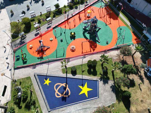 Turuncu spor alanı ve lacivert oyun sahasını birlikte gösteren park görünümü