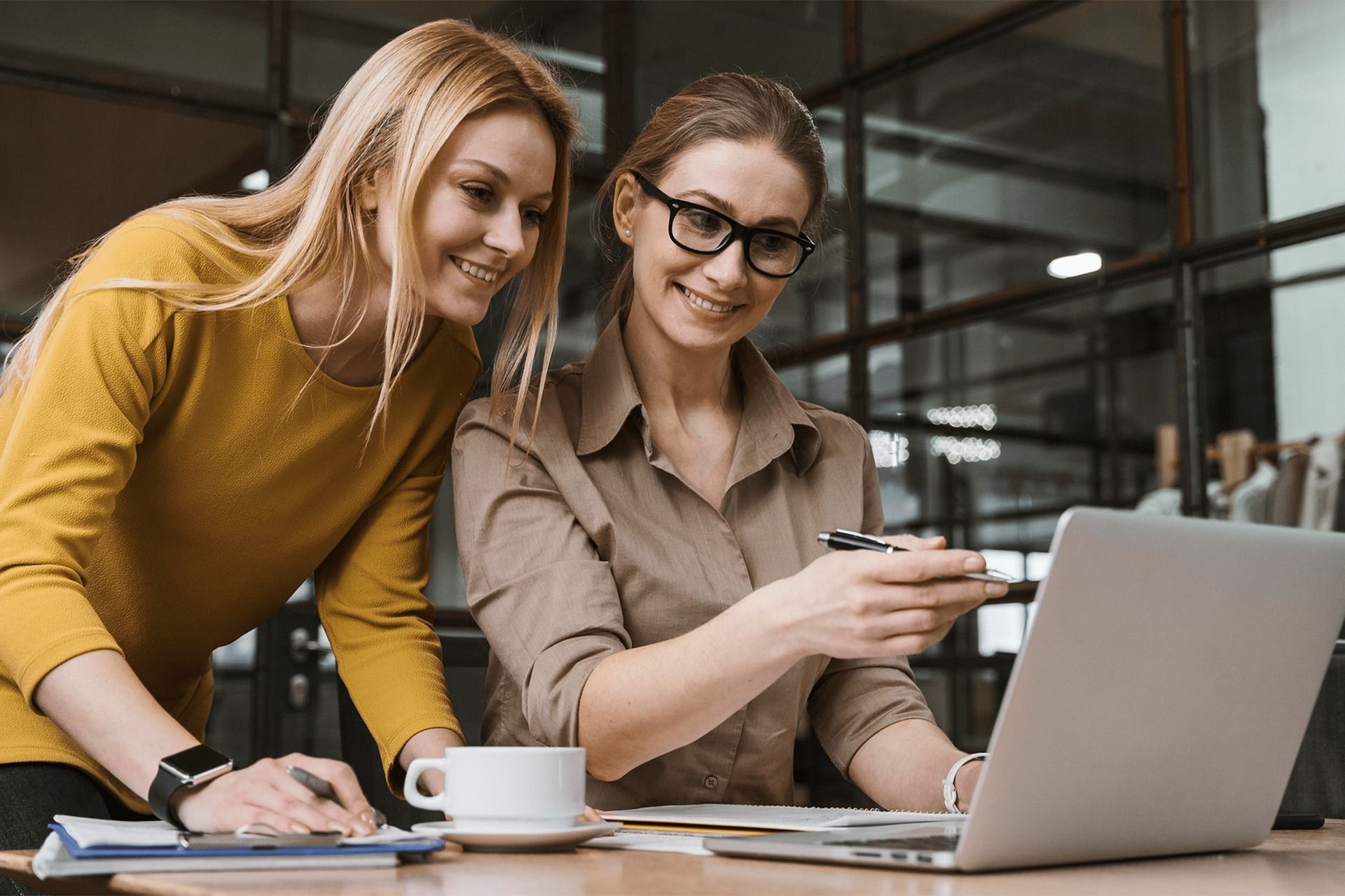 Two women infront of a laptop in an office