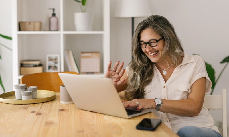 woman waving to computer