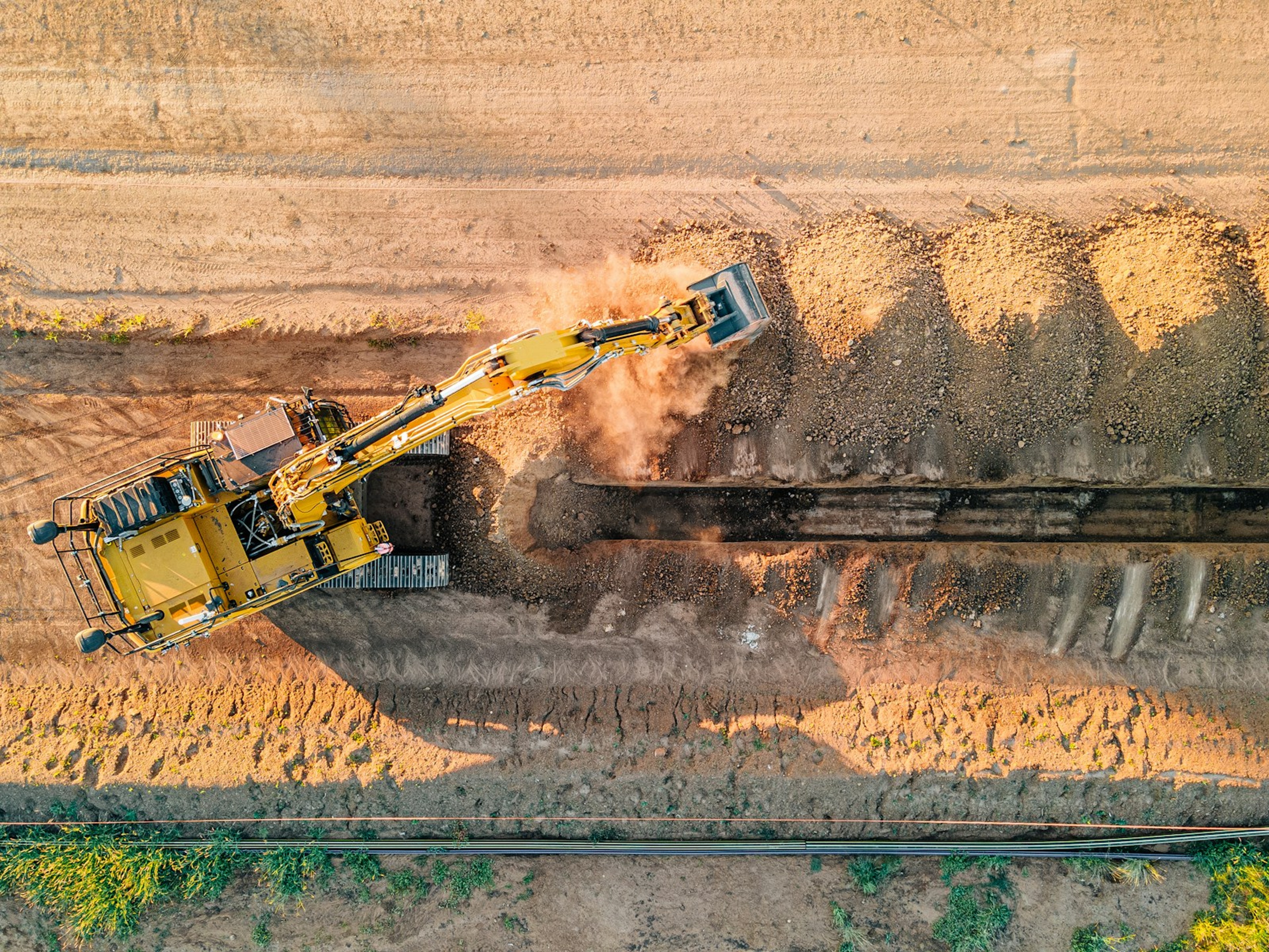 Excavator on an earthworks site, seen from the air