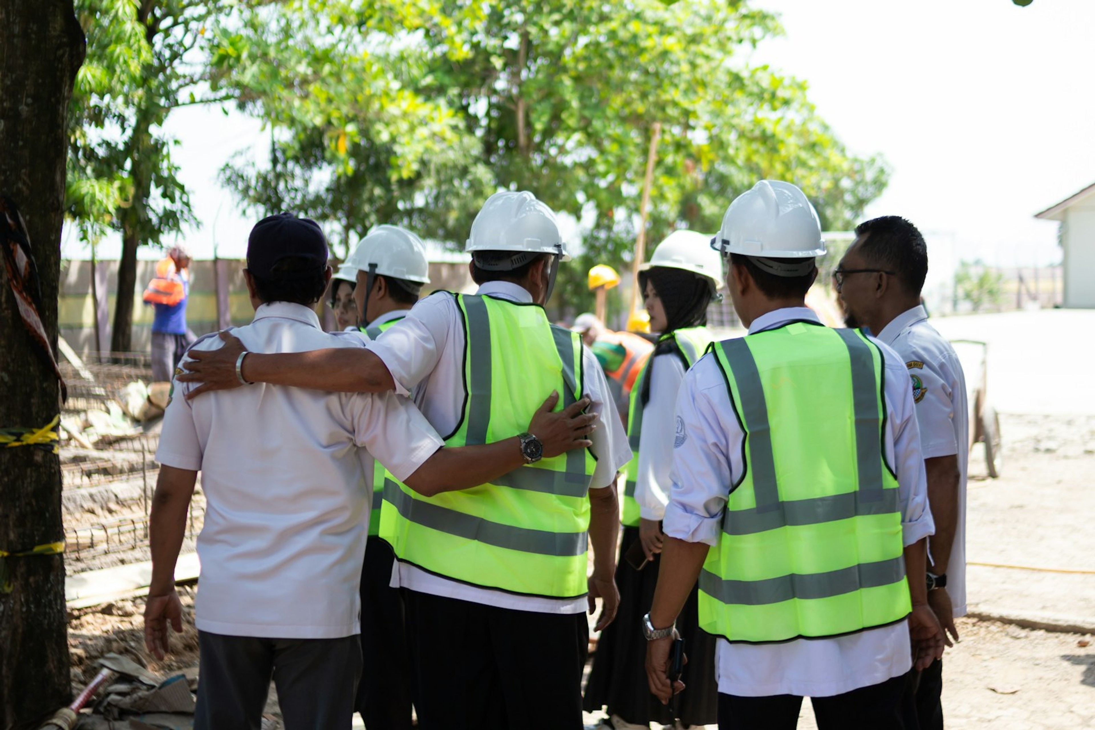 Group in high-visibility vests in conversation on site
