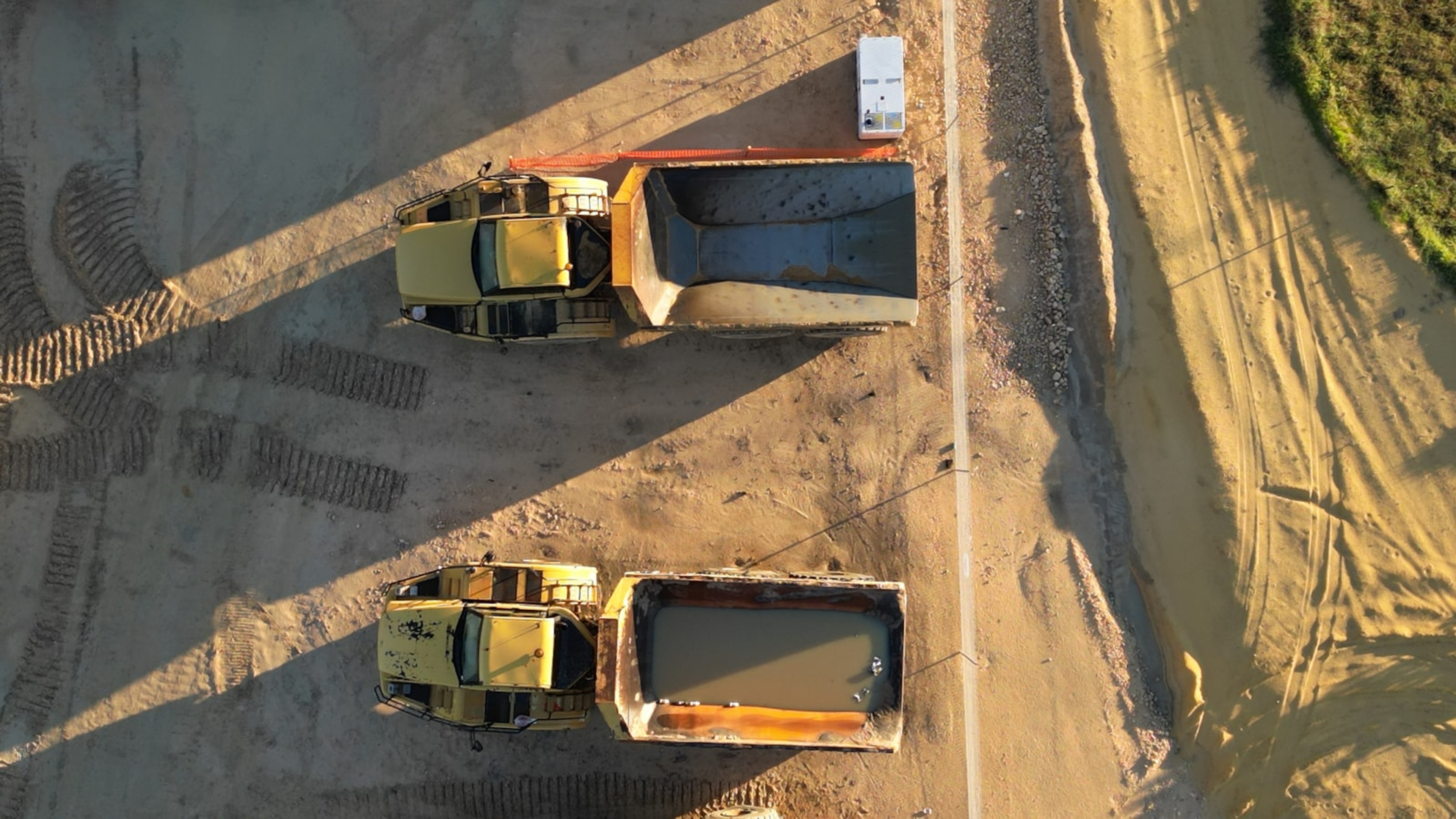 Dump trucks on an earthworks site from above