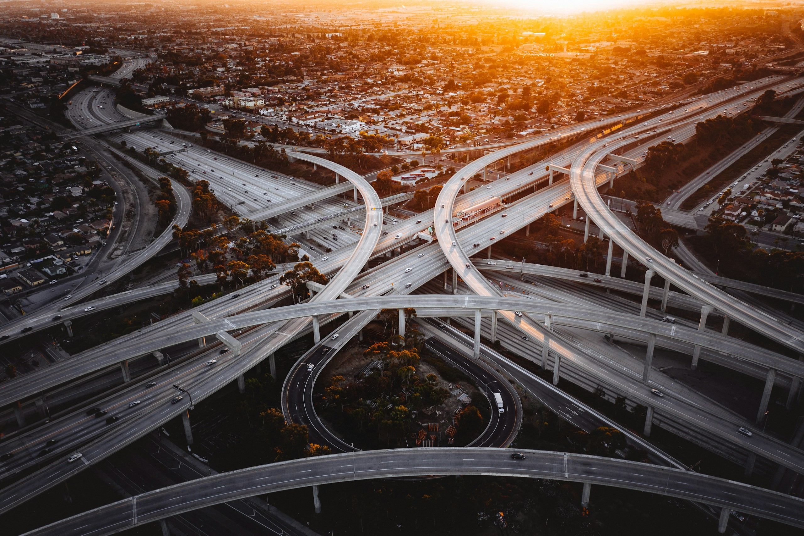 Multi-level motorway interchange at dusk with the city stretching to the horizon
