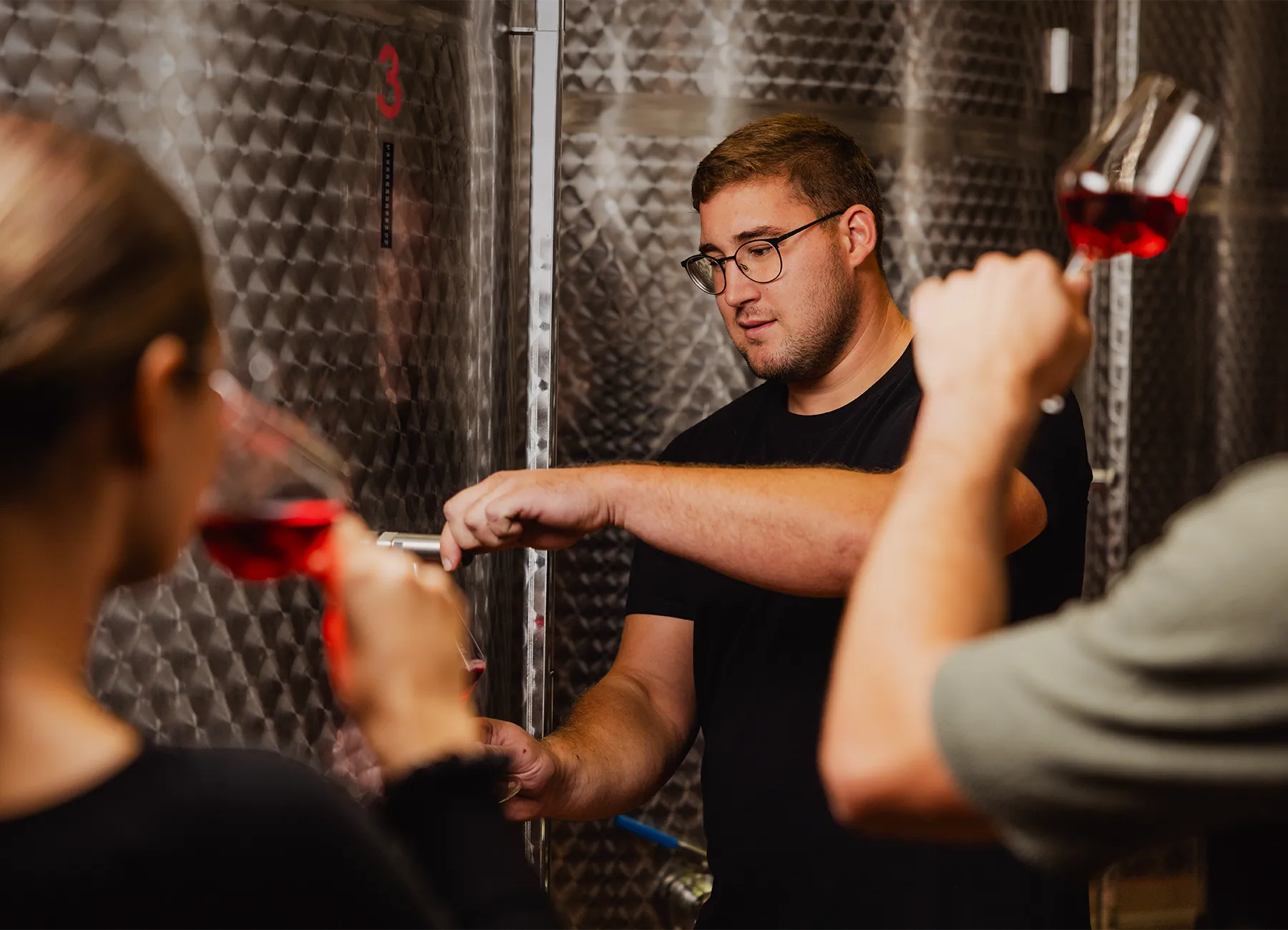 Guests tasting wine straight from the stainless steel tanks with the Jarkovič winemaker
