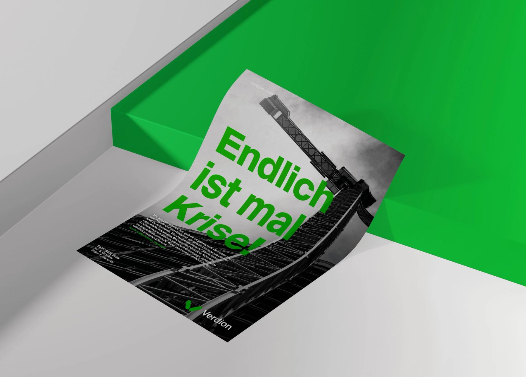 Verdion flyer “Endlich ist mal Krise!” on a green surface