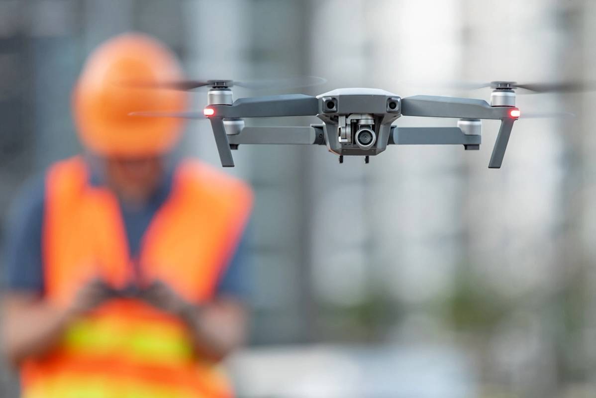 Bilder viser mann som styrer drone