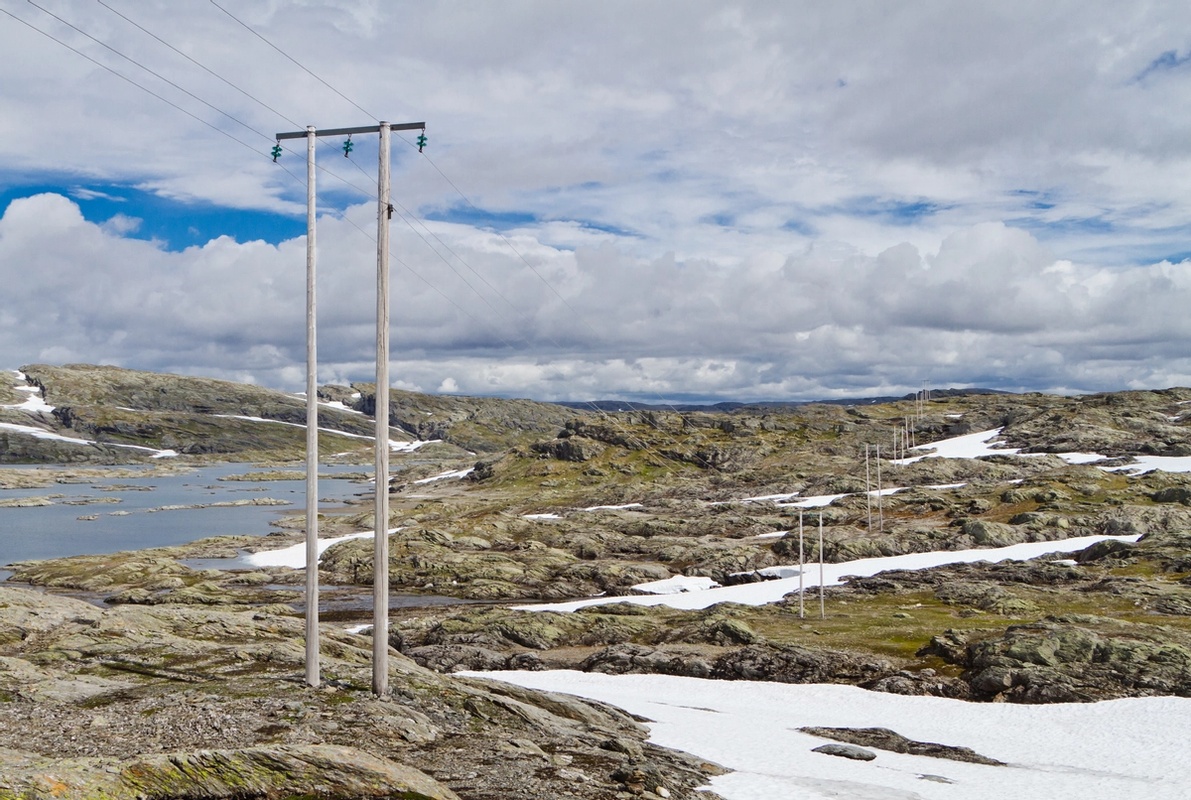Bilder viser strømstolper av tre i det nordiske fjellandskapet