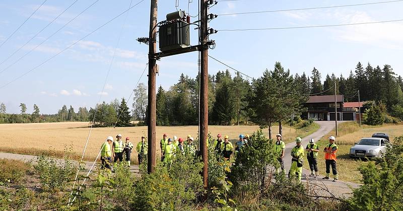 På bildet ser du folk som utfører en visuell kontroll av nettstasjon i mast.