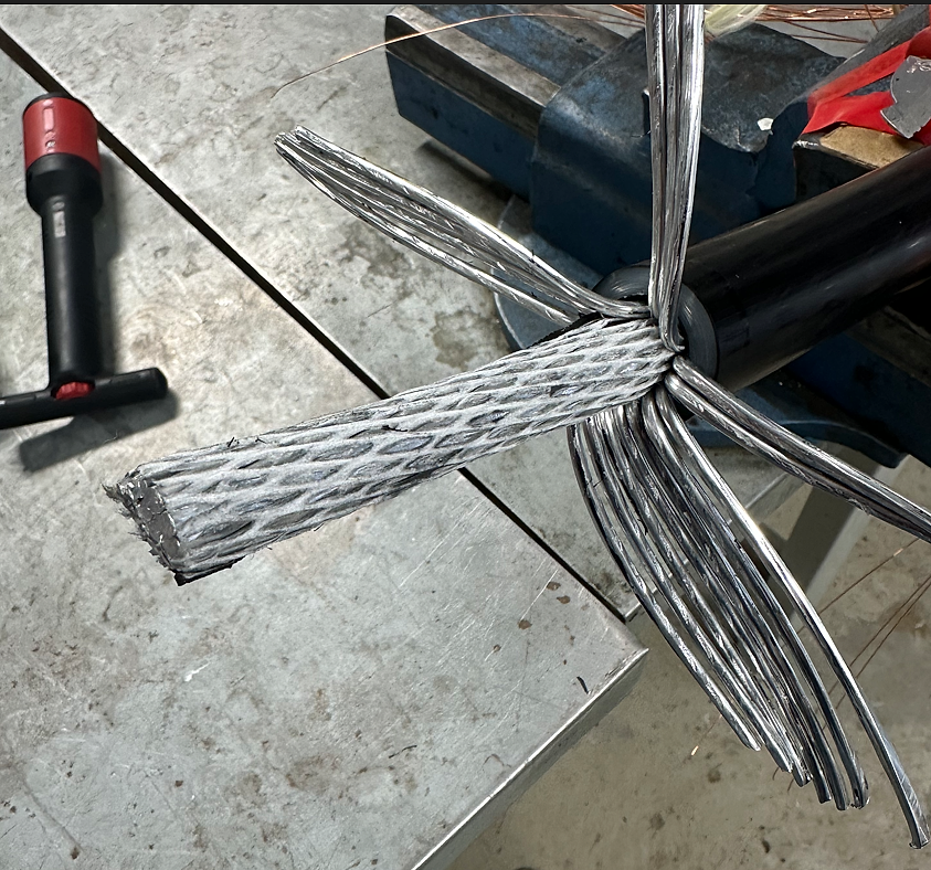 Nærbilde av en høyspentkabel der aluminiumstrådene er splittet og klargjort for skjøting eller terminering.
