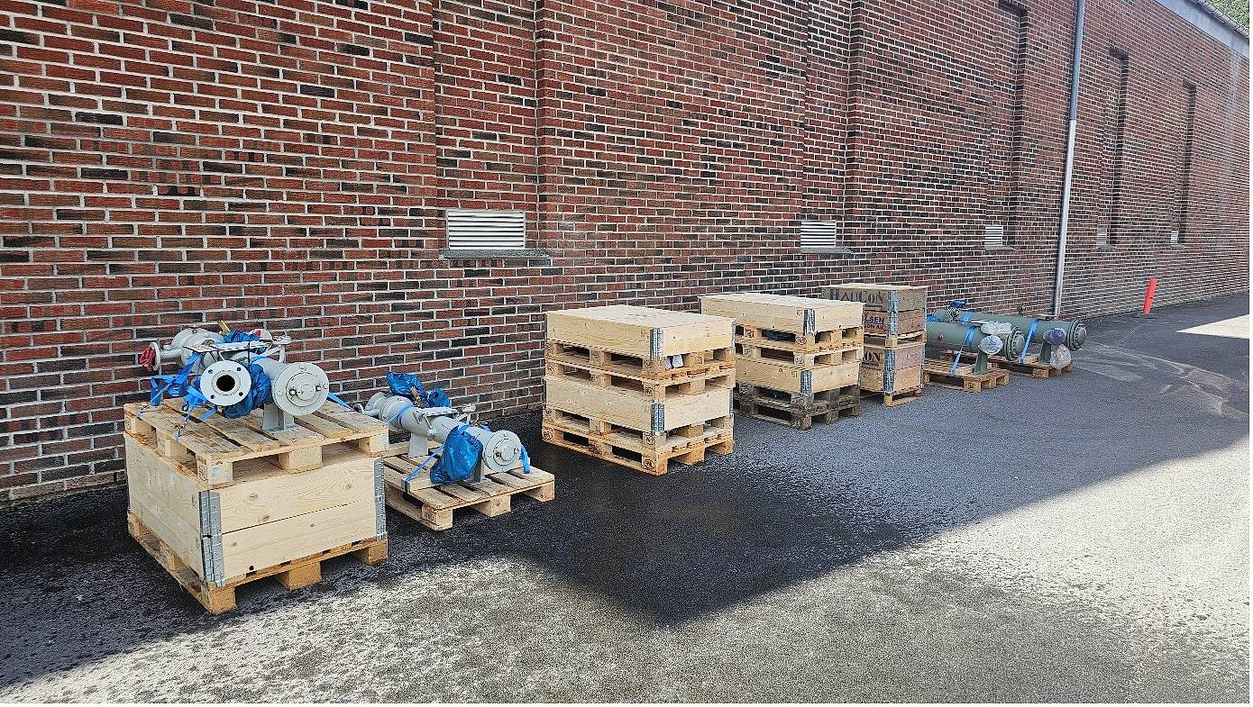 Bildet viser kasser med kjølere og tilkoblinger utenfor et murbygg.