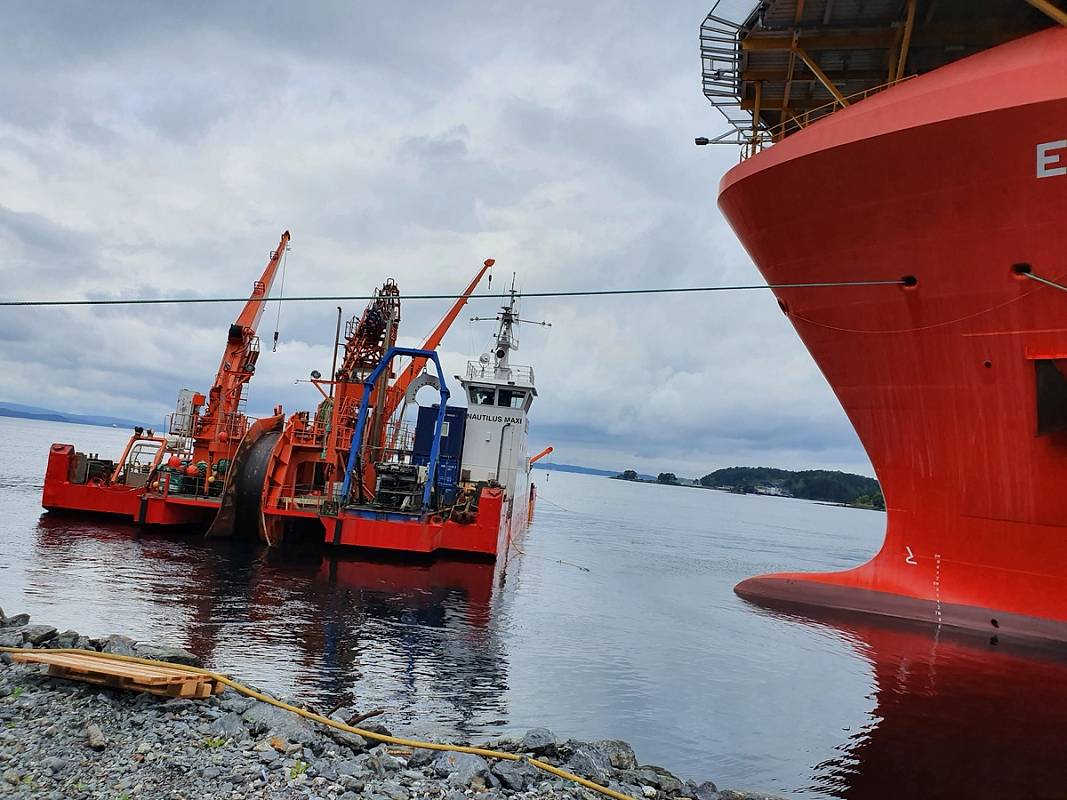 Bildet viser lasting av sjøkabel fra land til båt.