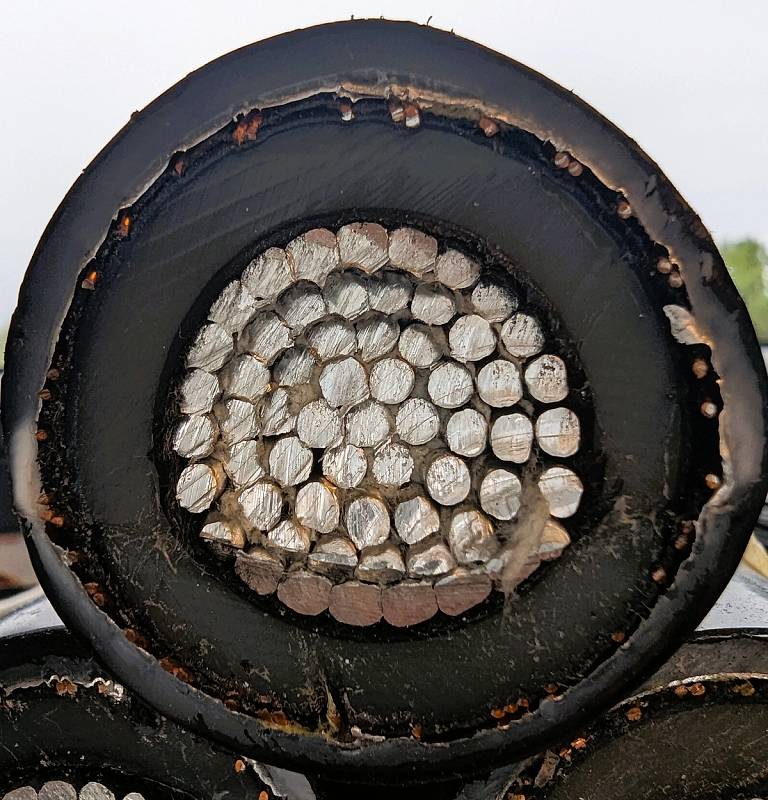 Tverrsnitt av en aluminiumskabel som viser den flertrådede lederen omgitt av isolasjon og ytre kappe.