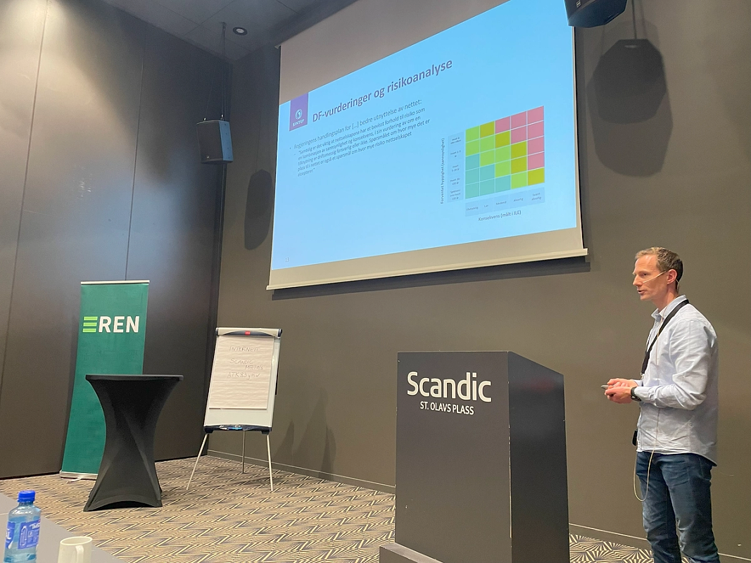 Bilde av mann som står foran talerstol.