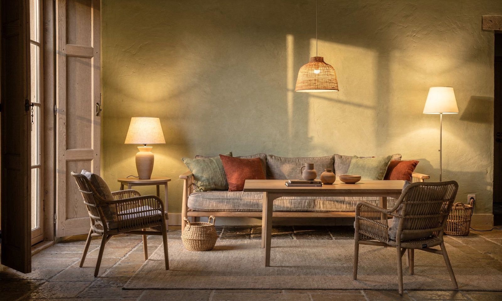Living room in Antibes lit in the evening by warm lamps and a soft floor lamp