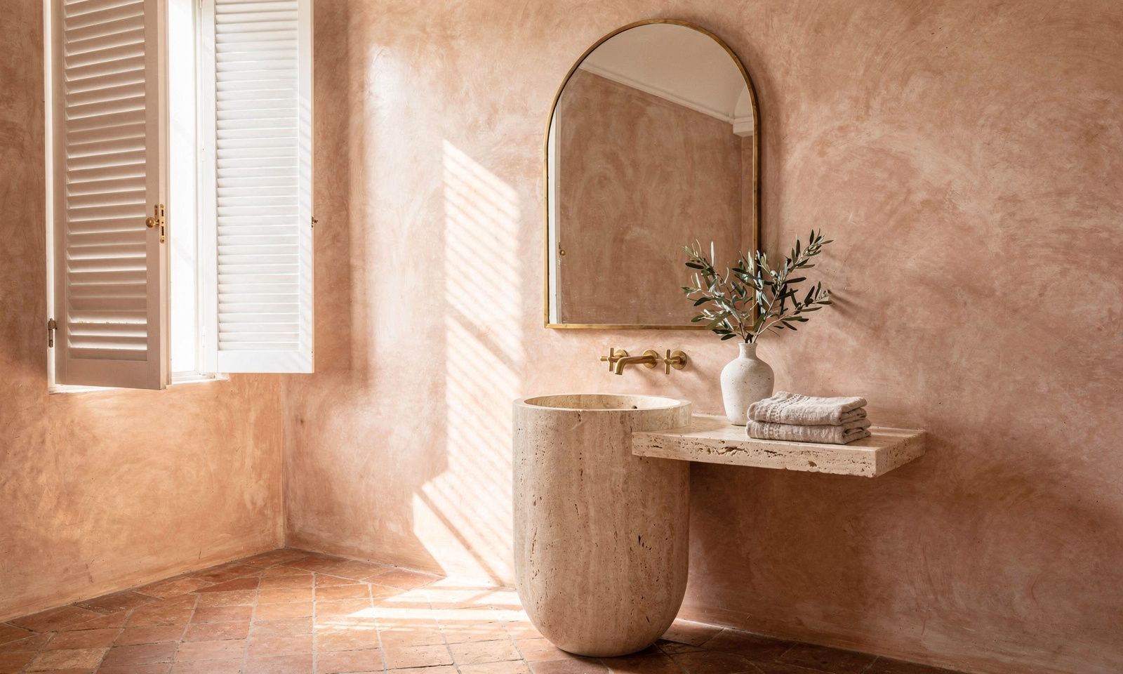 Salle de bain d'été à Cannes avec mur en tadelakt sable, vasque en travertin et lumière douce