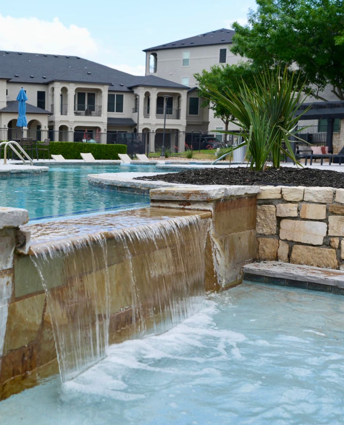Stacked-Stone Pool Waterfall | Hutto, TX Commercial Landscaping