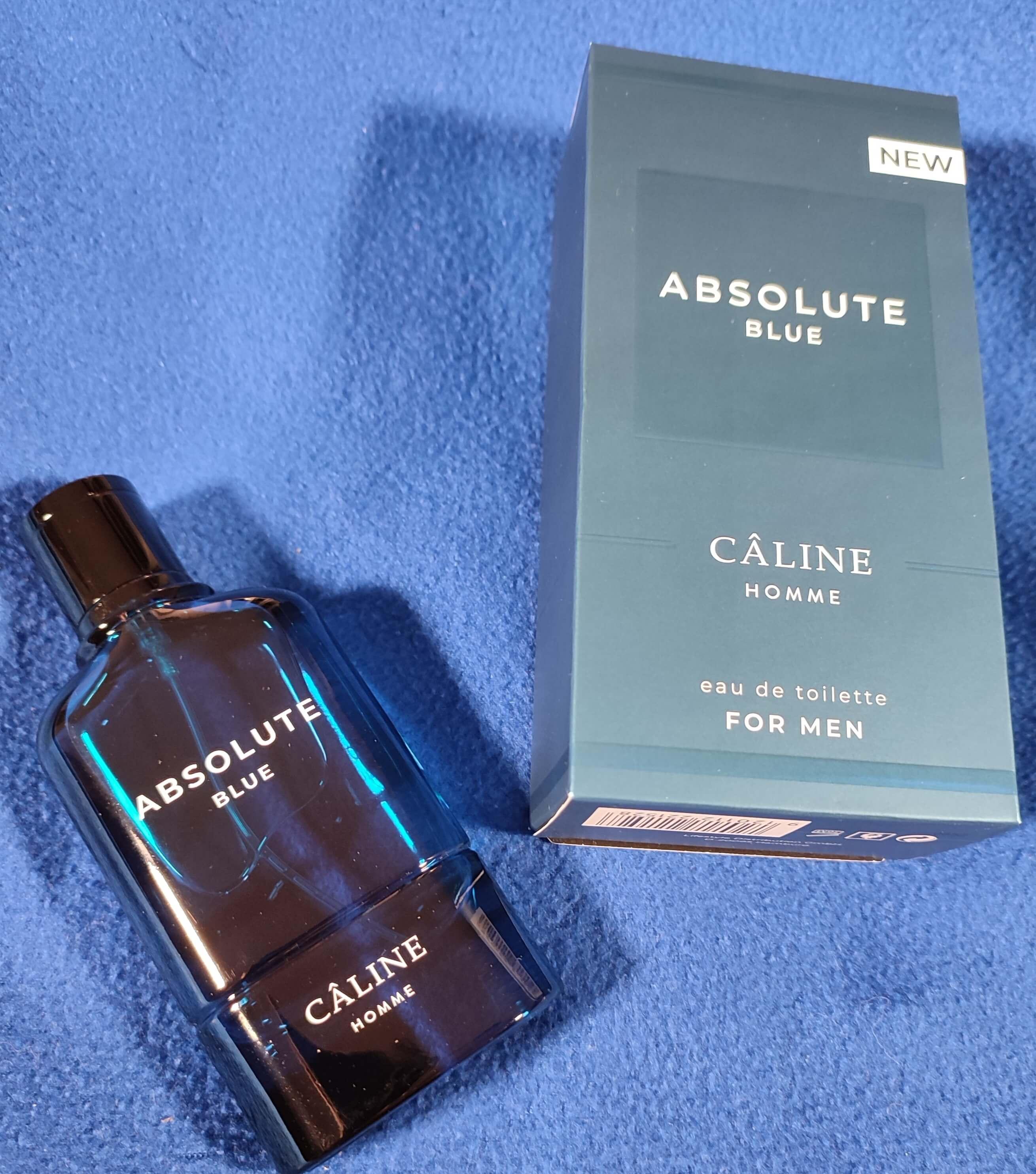 Parfüm der Marke "Caline Homme" - im Duft "Absolute Blue" präsentiert auf einem blauen Hintergrund