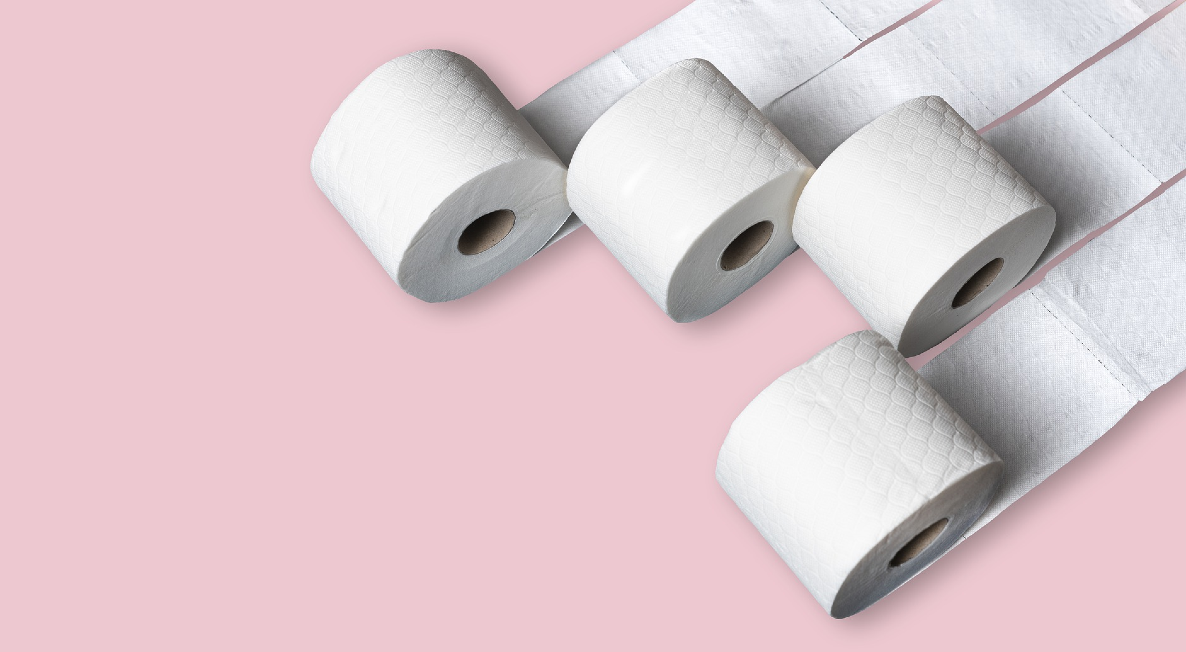 Mehrere Rollen Toilettenpapier vor pinkem Hintergrund.