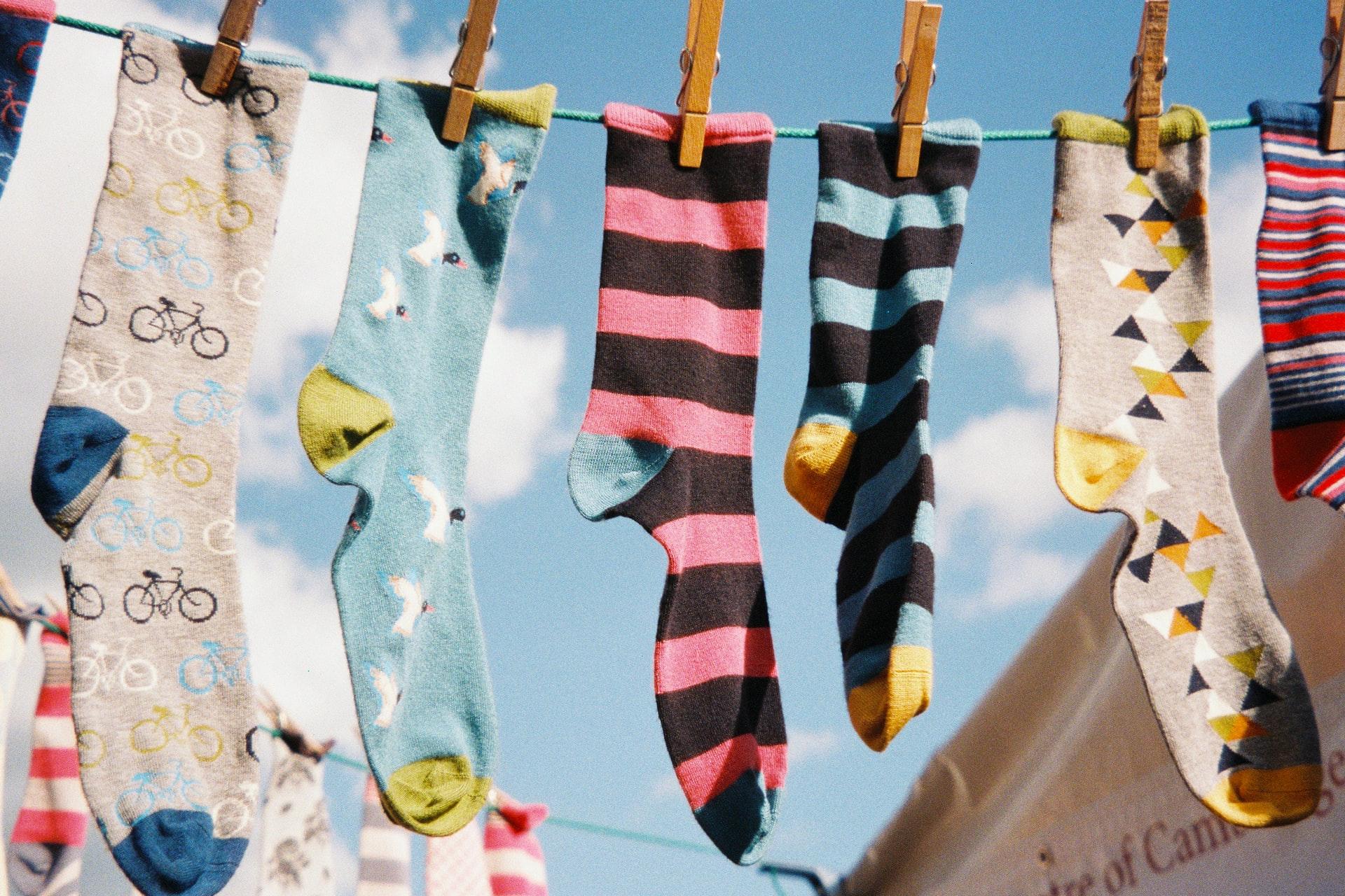 Verschieden farbige Socken auf einer Wäscheleine.
