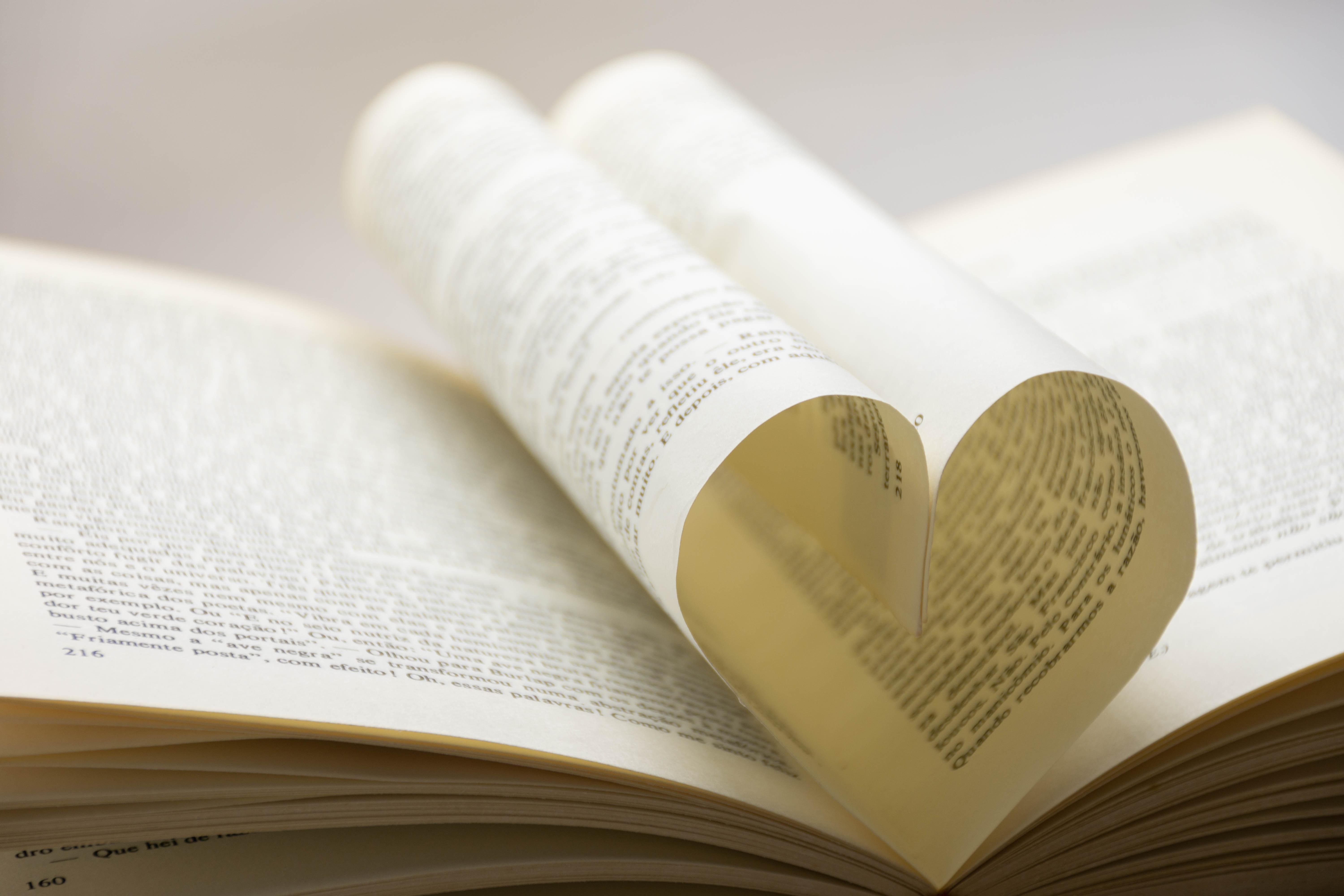 Zu sehen ist ein Buch. Zwei Seiten sind so gefalten, dass diese ein Herz formen.