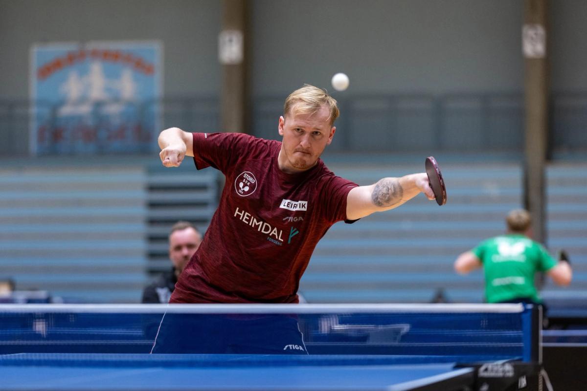Bordtennisspiller strekker seg etter ballen