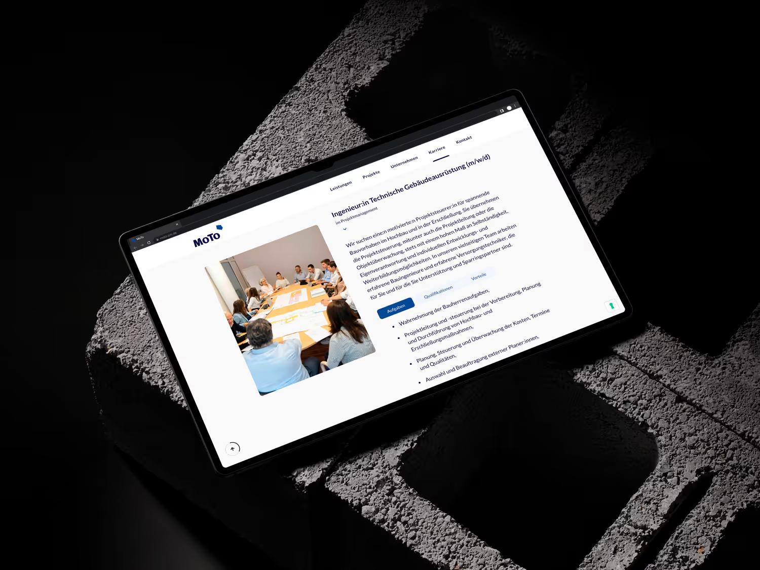 Page prestations de MoTo sur une tablette, avec une photo de réunion de projet et une liste de services