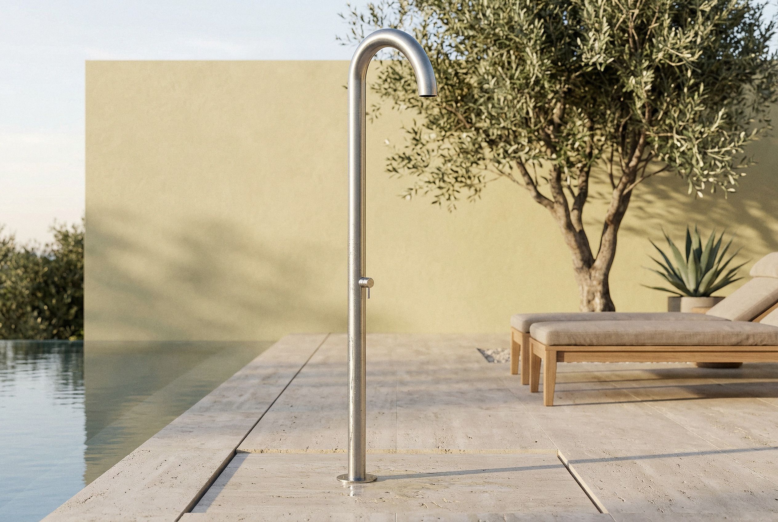 Colonna doccia freestanding Club C90.M in acciaio inox a bordo di una piscina a sfioro, in una villa mediterranea con ulivo