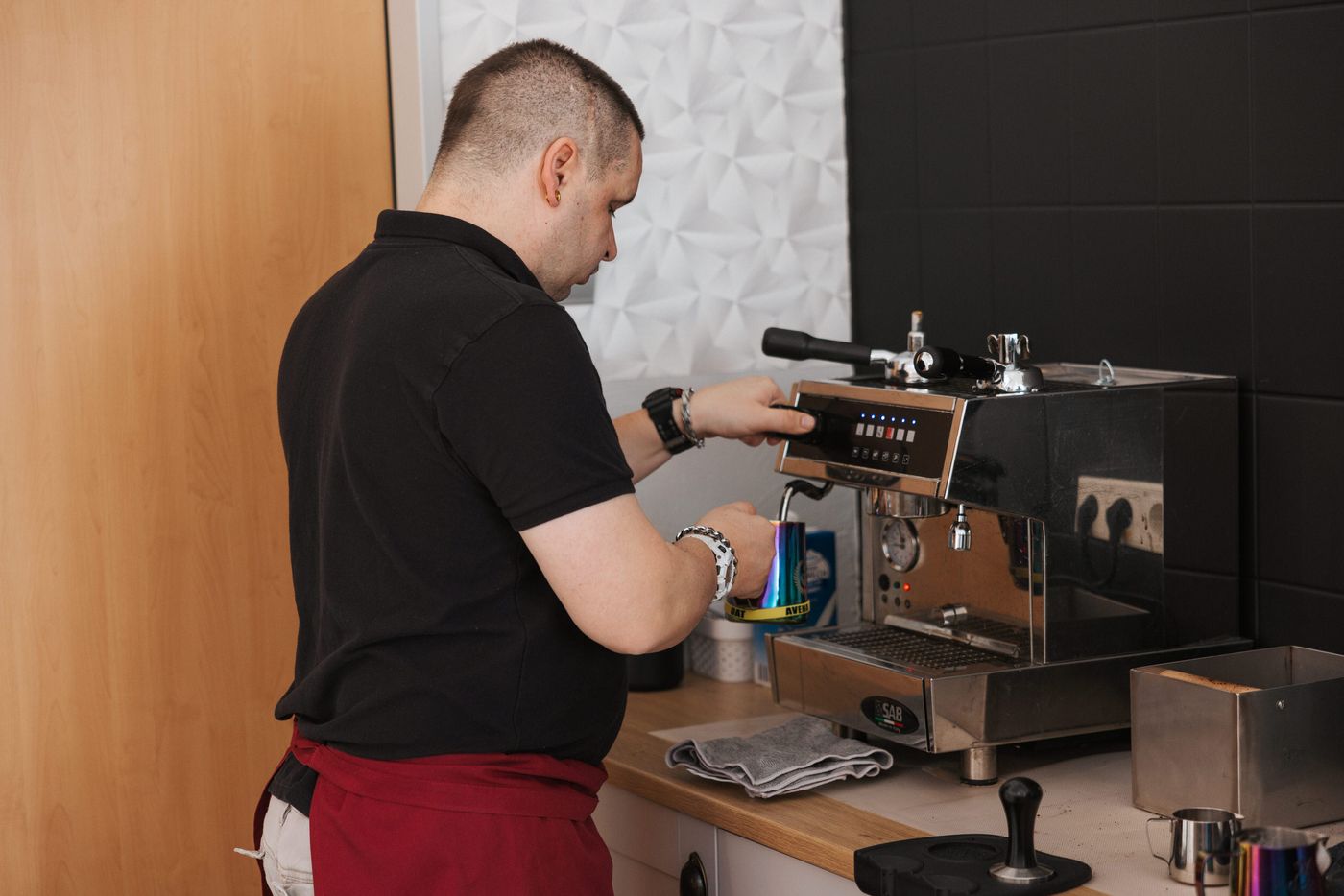 Beschäftigter bereitet als Barista an der Siebträgermaschine einen Espresso zu
