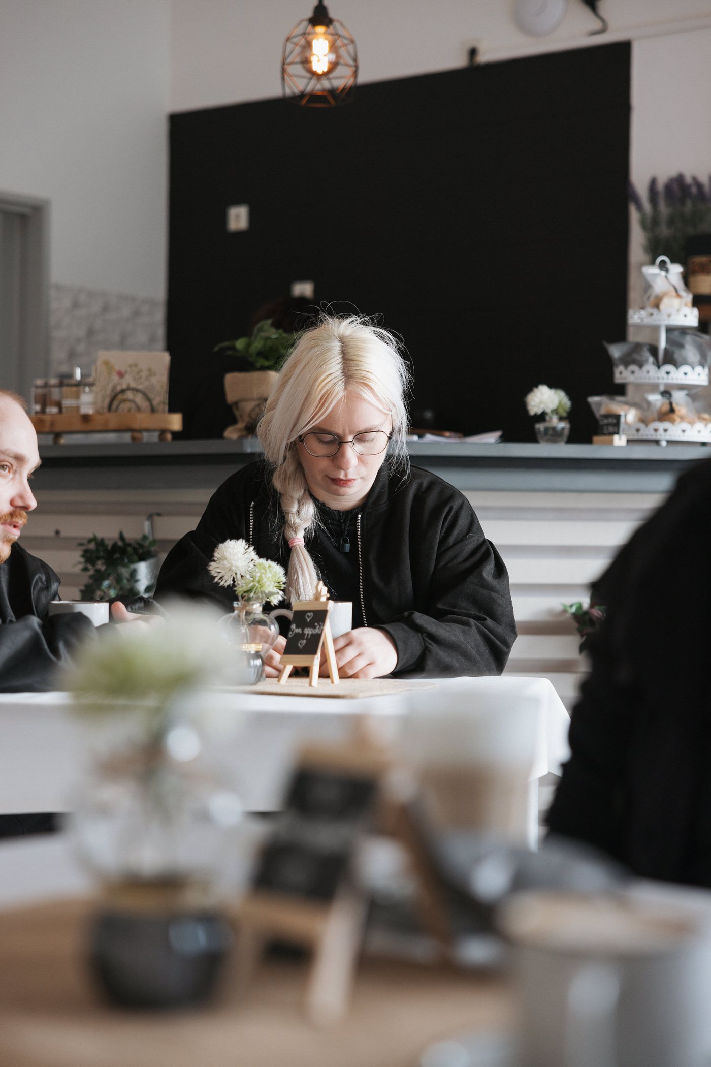 Gast am Cafétisch mit Blick auf die Kuchentheke