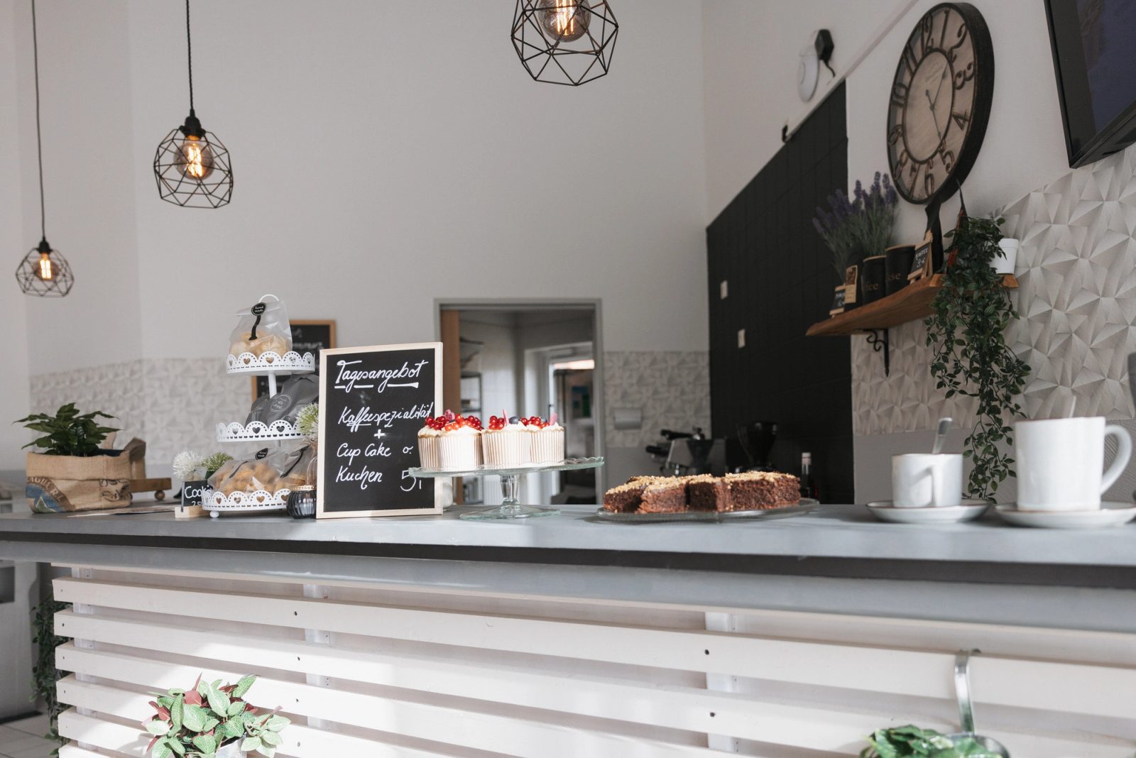 Café-Theke der Stiftung Samariterherberge mit Kuchen, Tassen und Wanduhr