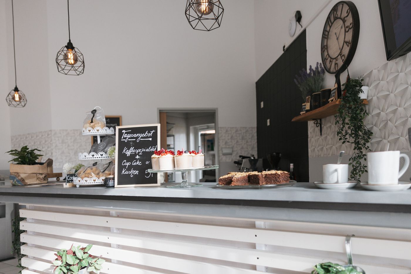 Café-Theke der Stiftung Samariterherberge mit Kuchen, Tassen und Wanduhr