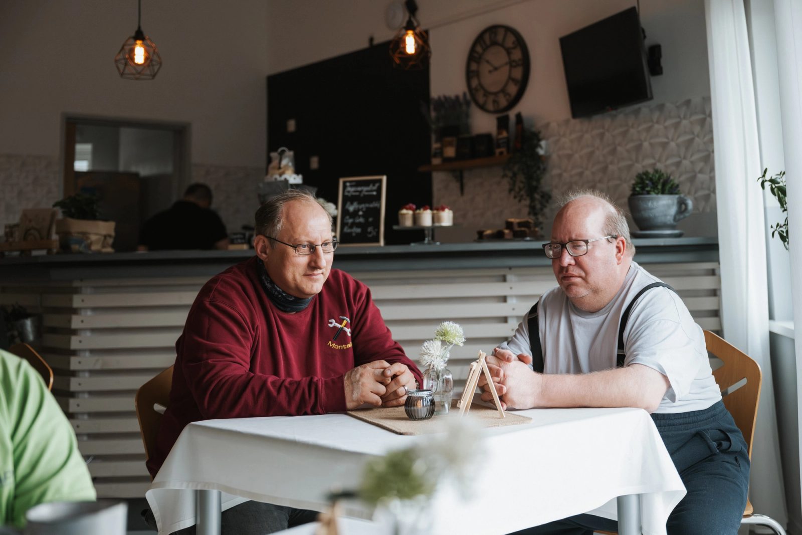 Zwei Gäste im Gespräch bei Kaffee am Cafétisch