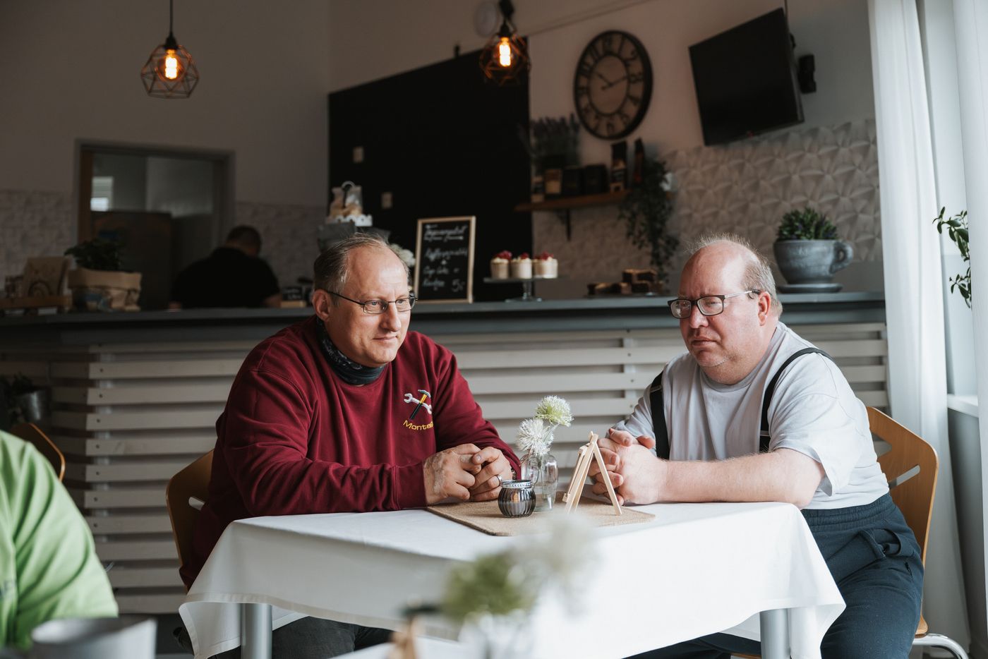 Zwei Gäste im Gespräch bei Kaffee am Cafétisch