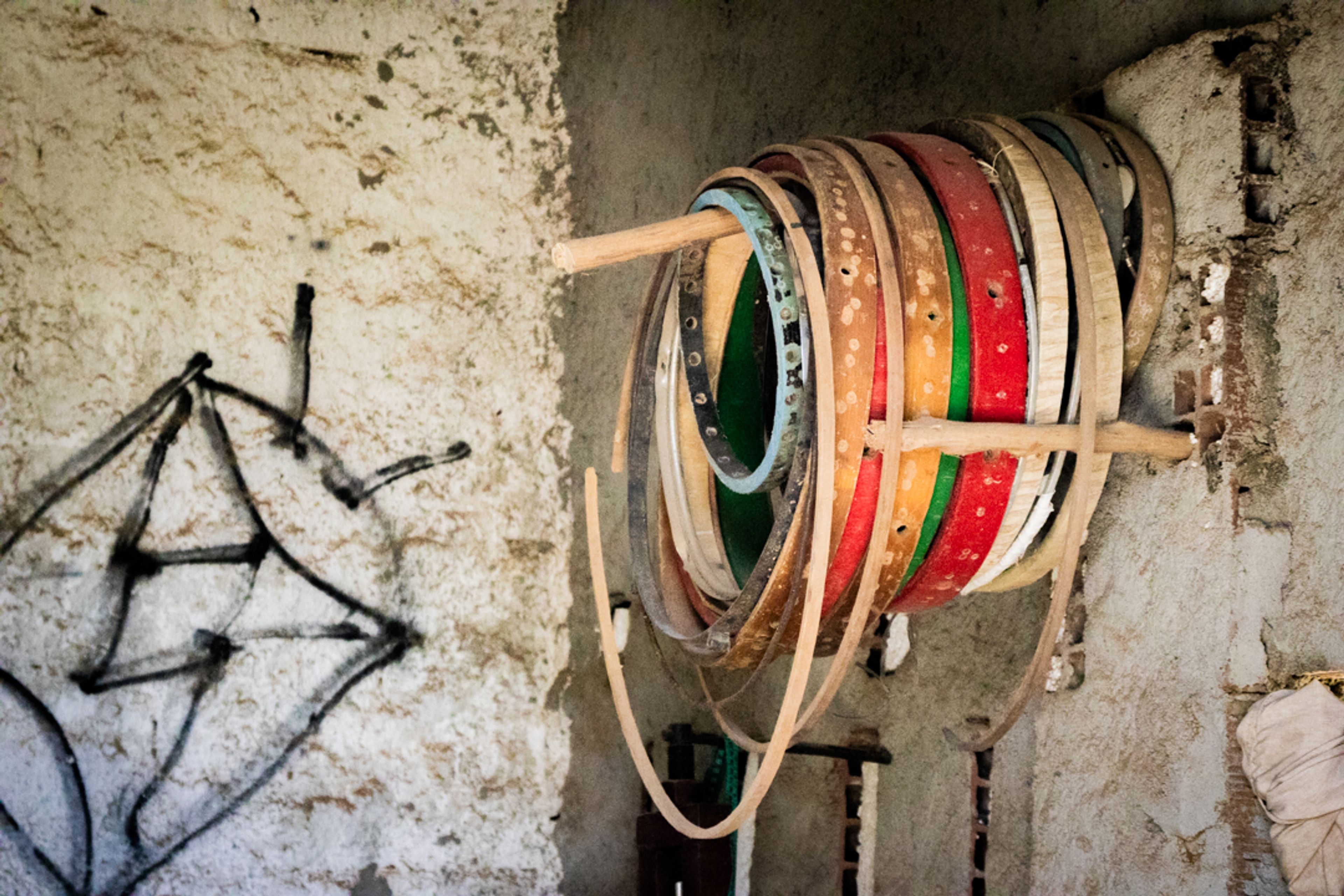 Aros de tambores dependurados ao lado direito e um tambor desenhado do lado esquerdo.