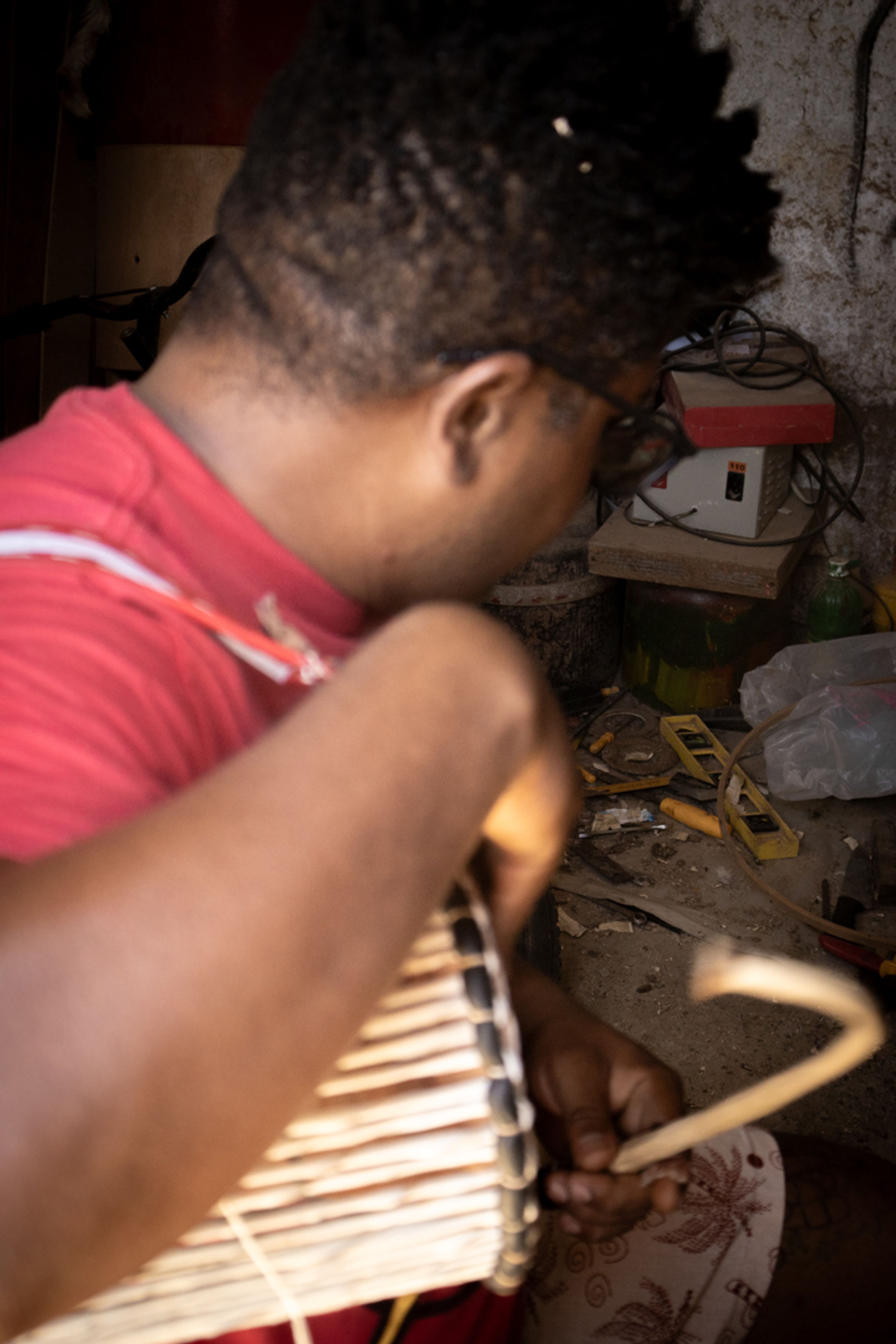 Bolinho tocando seu instrumento em primeiro plano, no segundo plano ateliê.