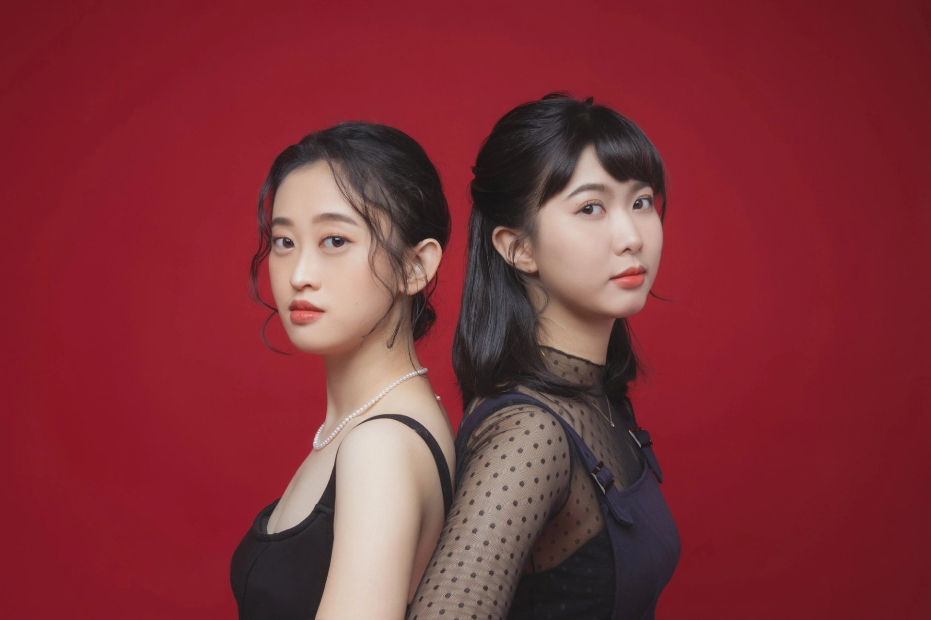 閨蜜寫真－紅色背景兩位黑色上衣女性背靠背