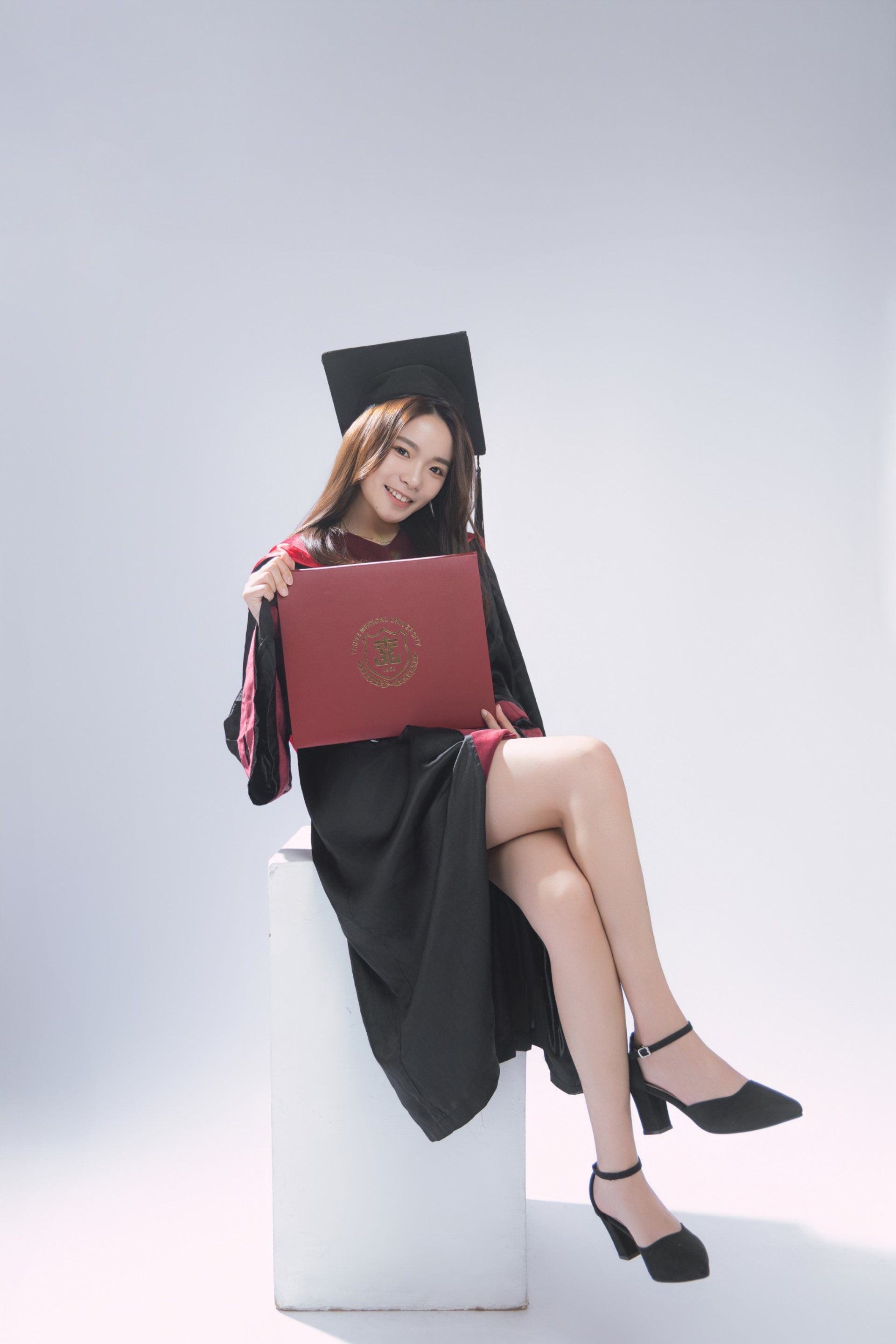 畢業寫真－學士服女性坐姿持紅色證書夾棚拍