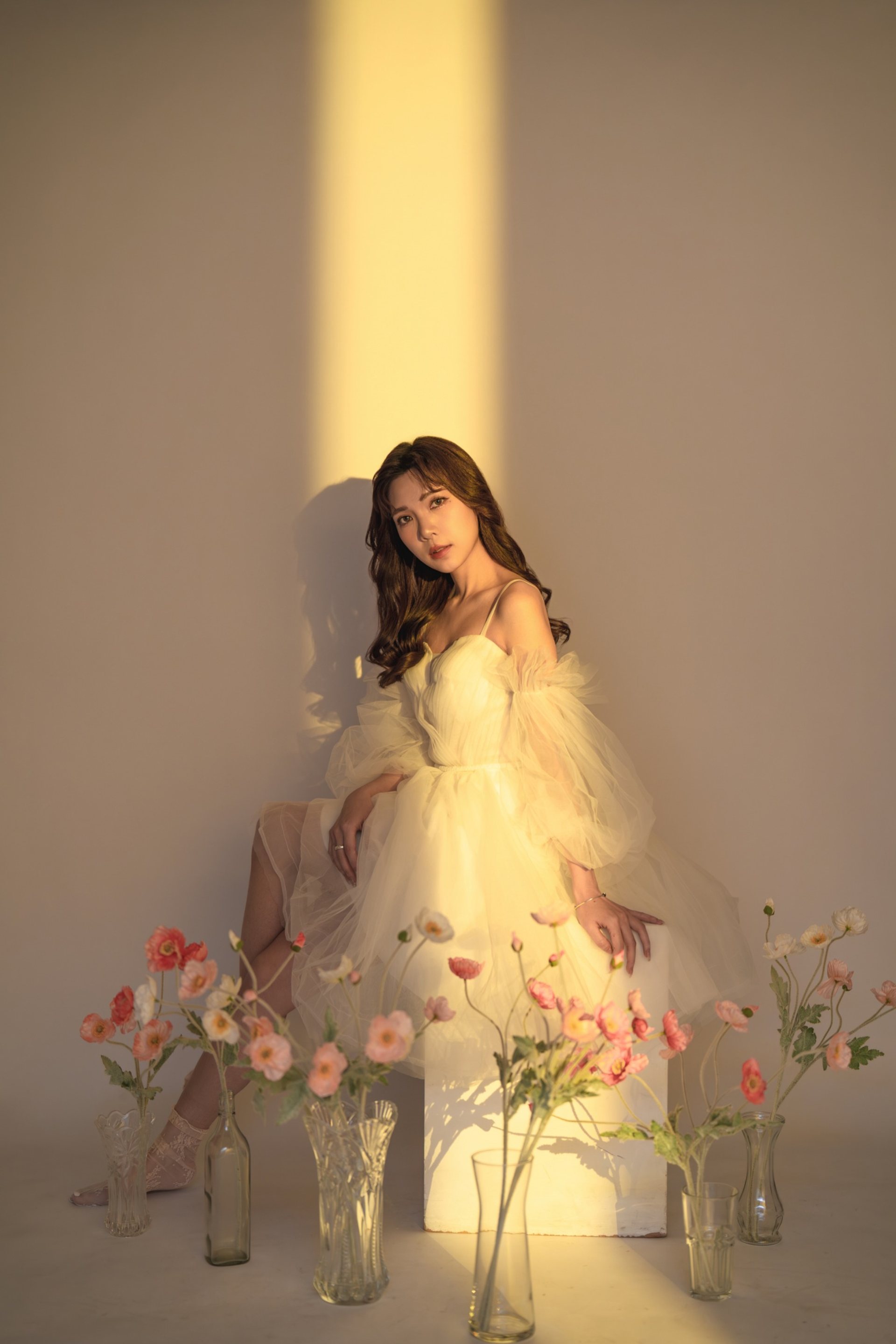 主題式寫真－白紗洋裝女性坐姿暖光花瓶花藝場景