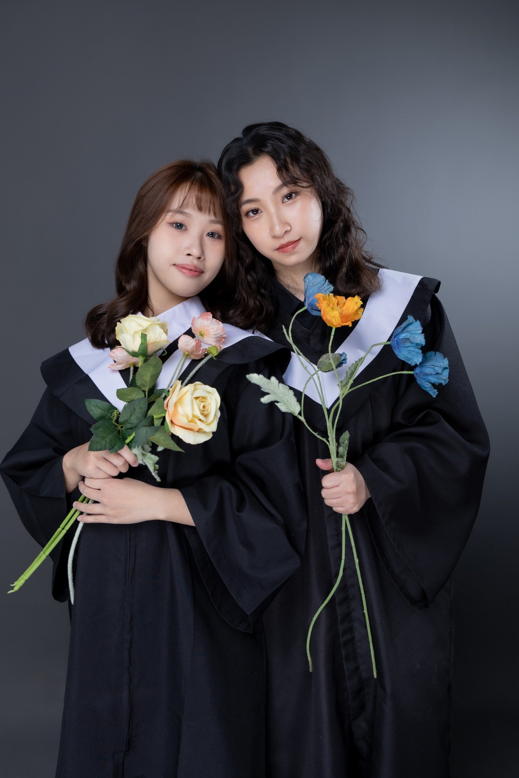 閨蜜寫真-兩位學士服女性手持花束深灰背景棚拍