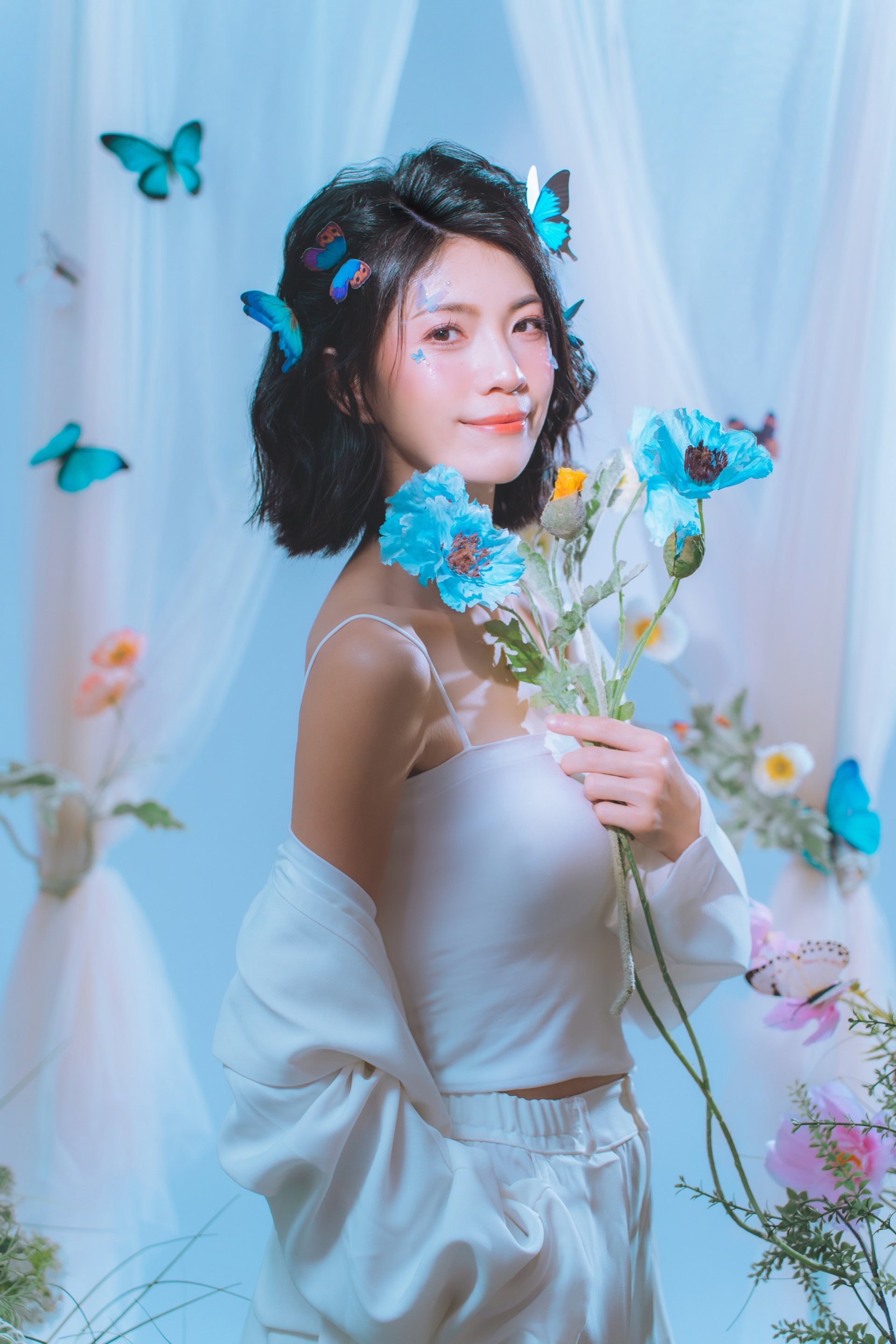 主題式寫真－白色洋裝女性持藍色花朵蝴蝶佈景